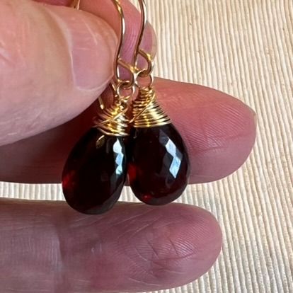 handgemaakte oorbellen door Daans Design met de wire wrap methode met 14 karaat gold filled draad en grote rode granaat edelstenen perfect voor een sjieke look